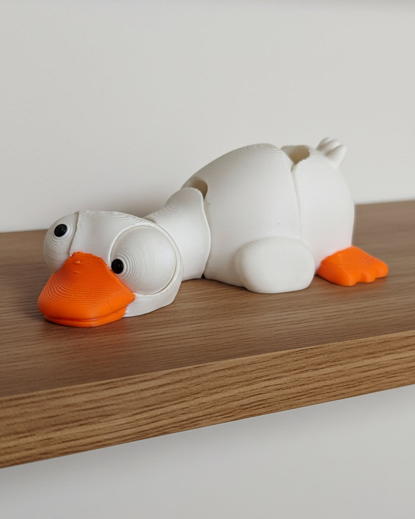 Gros plan d'une mini oie articulée aux grands yeux mobiles sur fond blanc