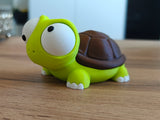 Détail d'une figurine de tortue aux yeux mobiles et au petit visage souriant