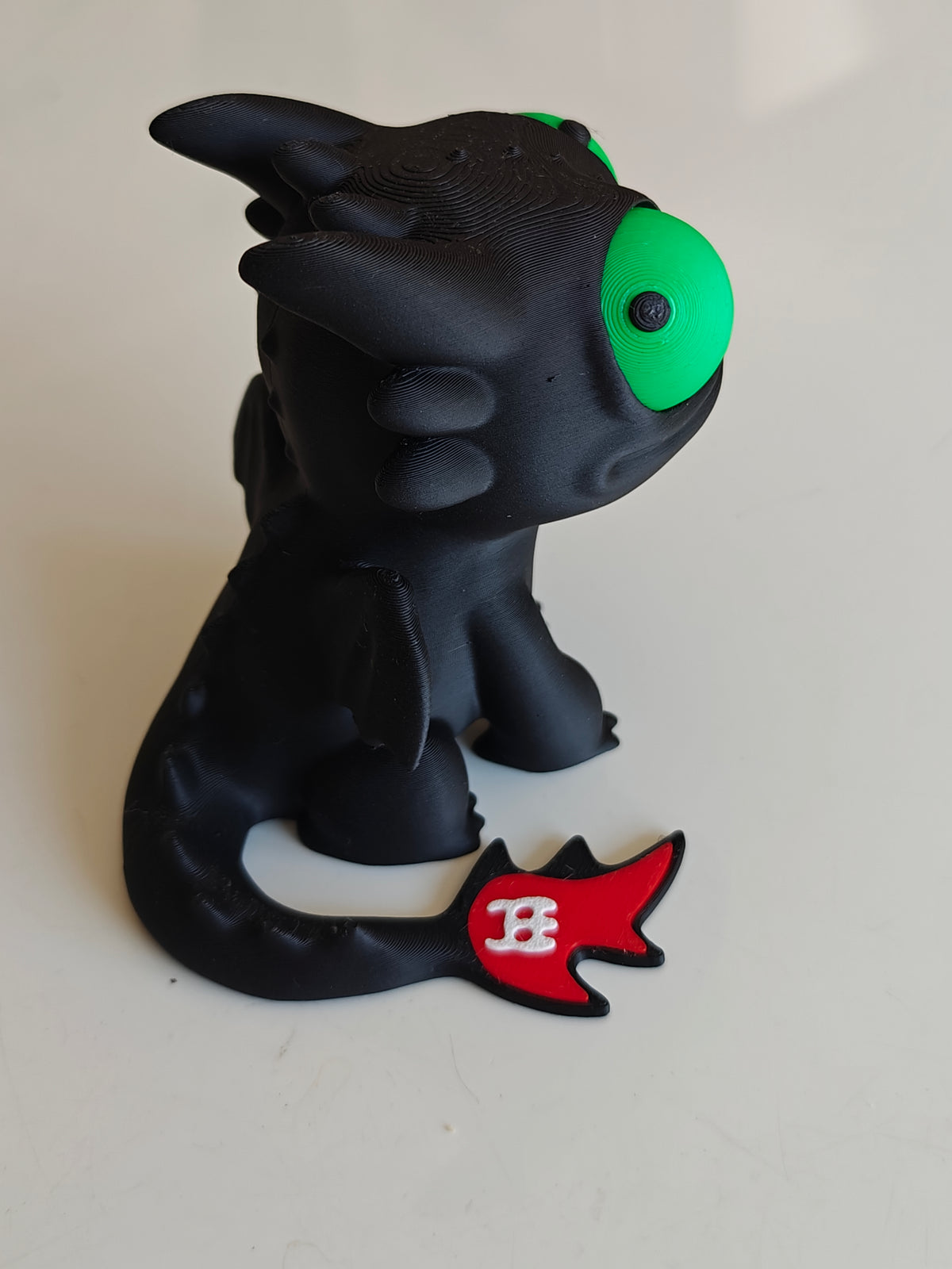 Figurine du dragon Krokmou aux grands yeux mobiles vue de face sur fond blanc