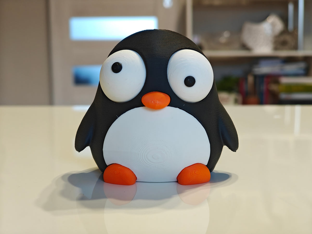 Figurine de pingouin rigolote aux yeux mobiles, gros plan sur fond blanc