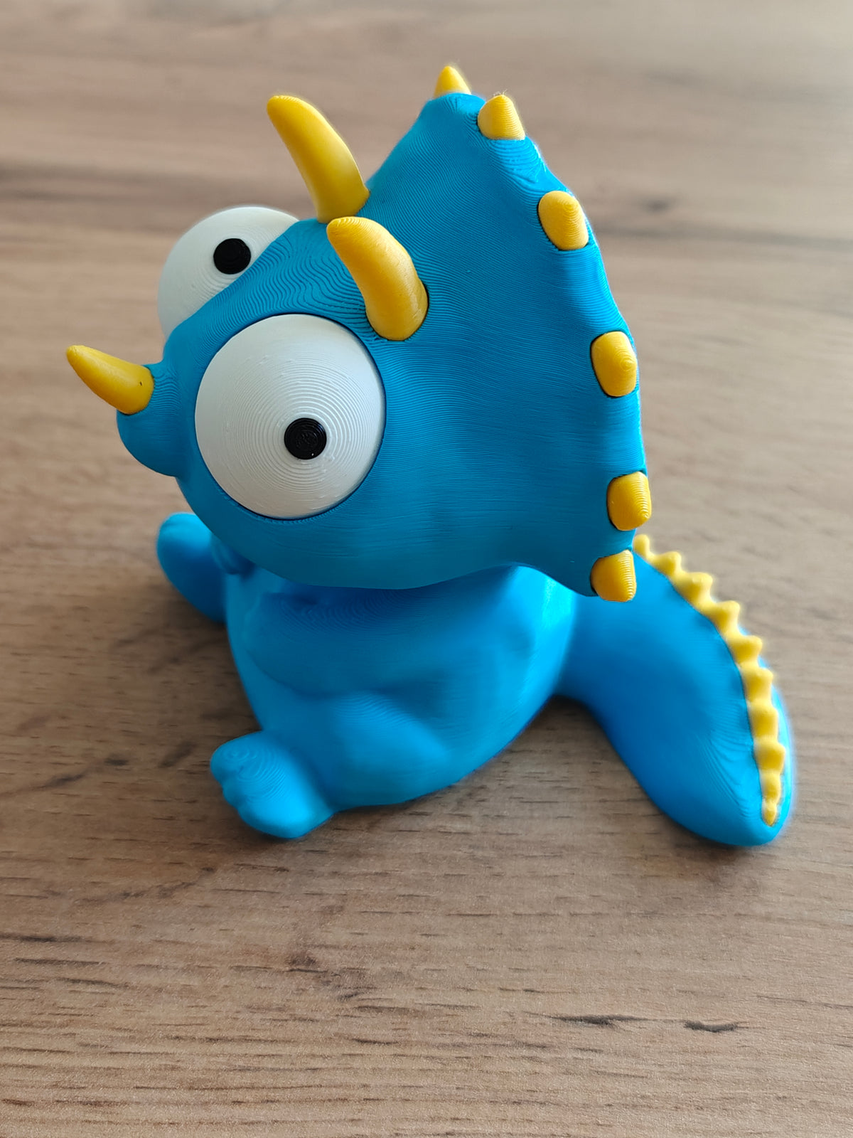 Gros plan des yeux mobiles d'une figurine de tricératops rigolote