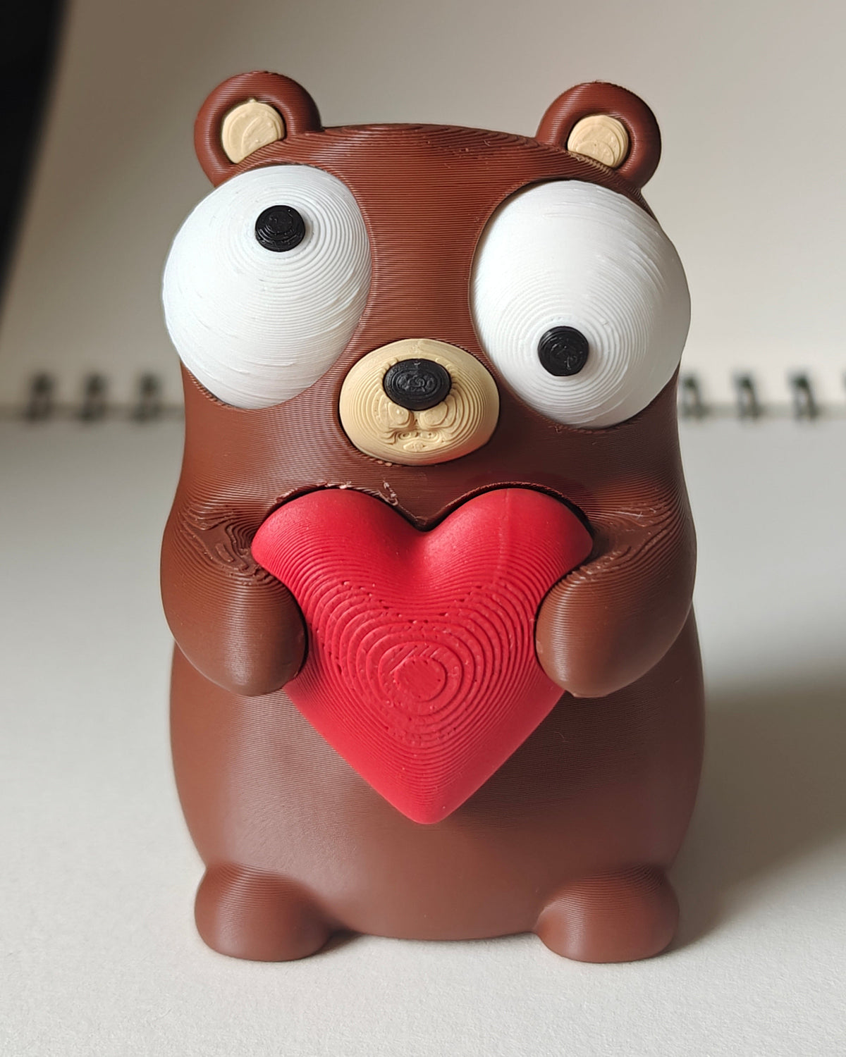 Gros plan d'une petite figurine d'ours avec cœur et grands yeux mobiles