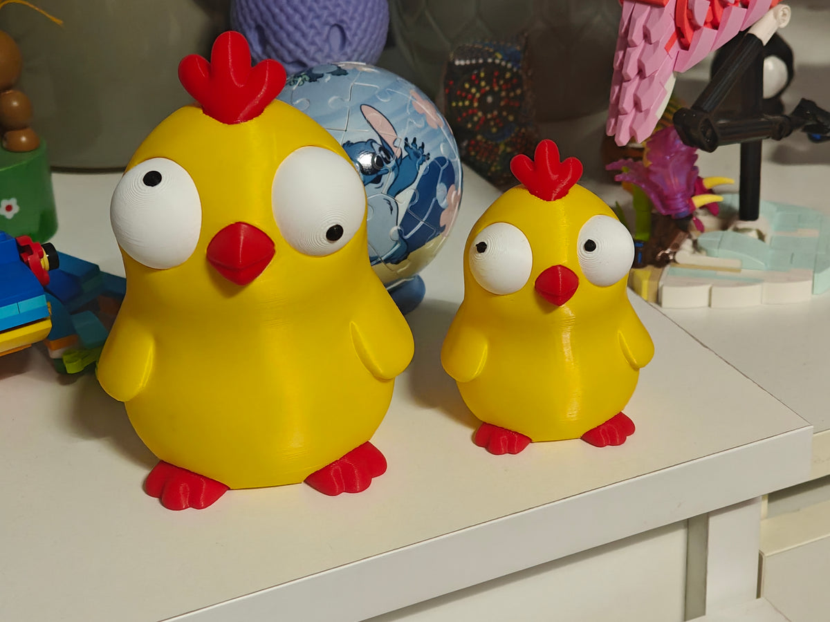 Gros plan d'une figurine de poussin amusante aux grands yeux mobiles sur fond blanc