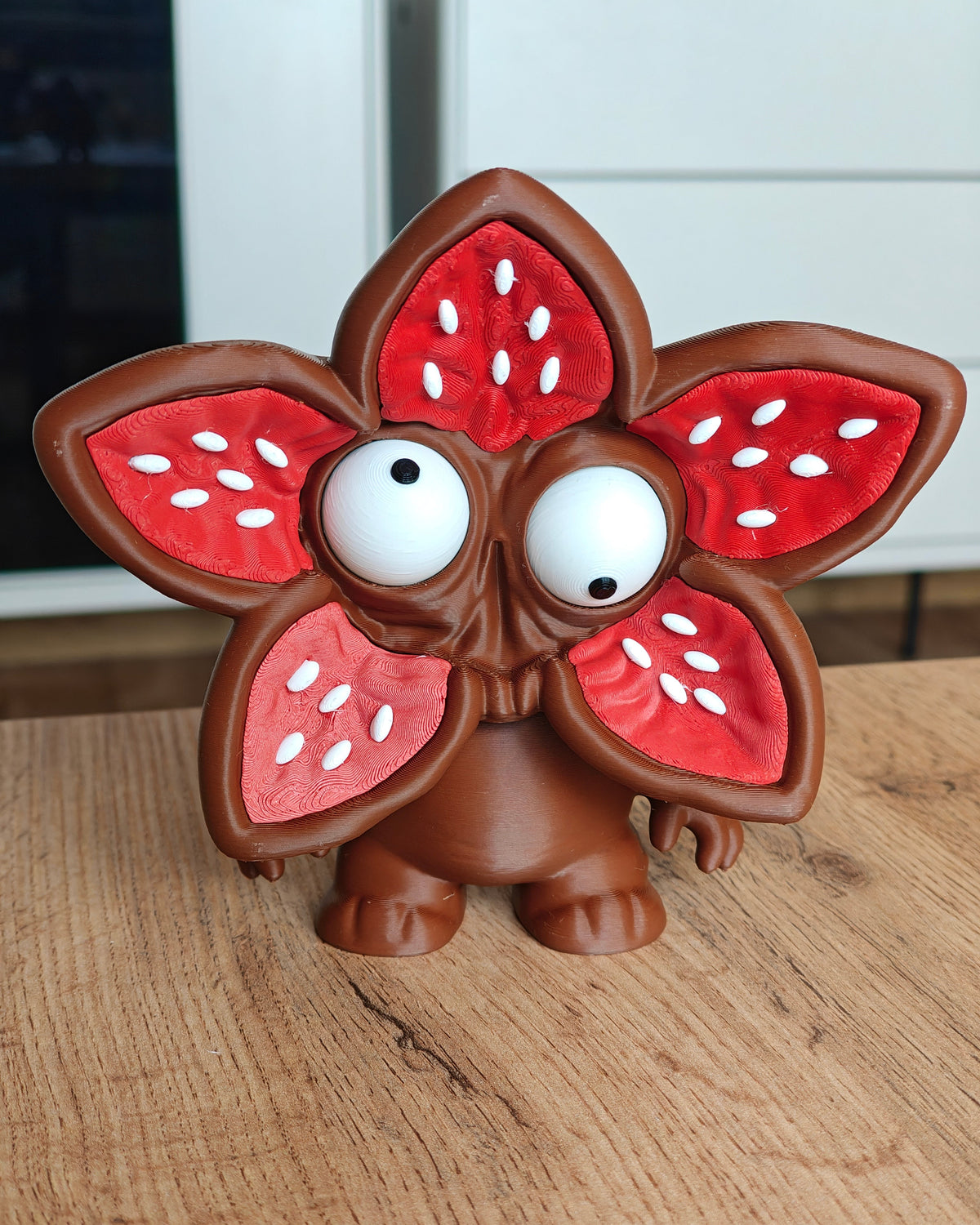 Figurine de monstre au visage de fleur et aux grands yeux mobiles, vue de face