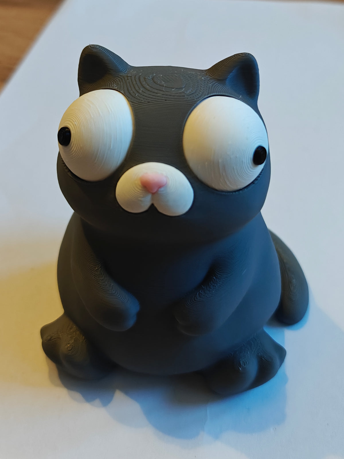 Gros plan d'une figurine de chat blanc dodu aux grands yeux mobiles