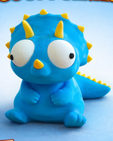 Figurine de tricératops rigolote aux yeux mobiles, gros plan sur fond blanc