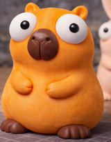Figurine de capybara aux grands yeux mobiles, vue de face sur fond blanc