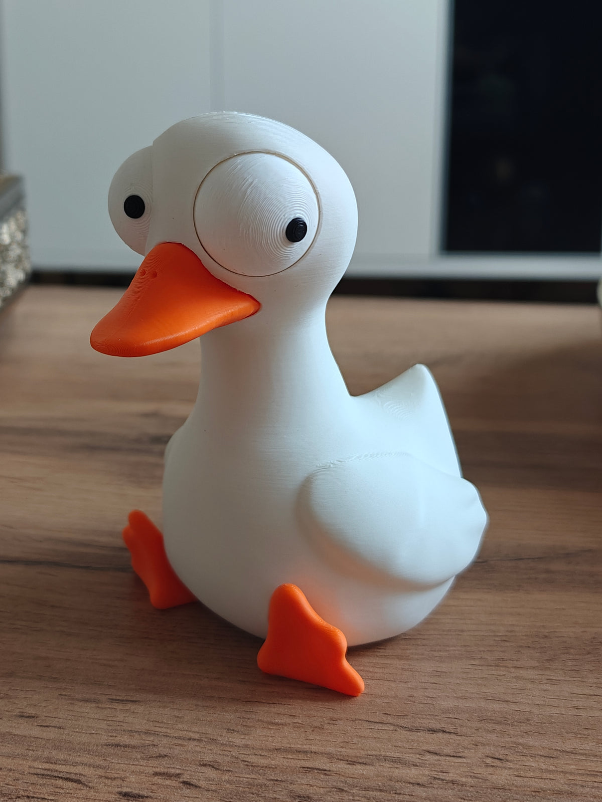 Figurine d'oie rigolote aux grands yeux mobiles sur fond blanc