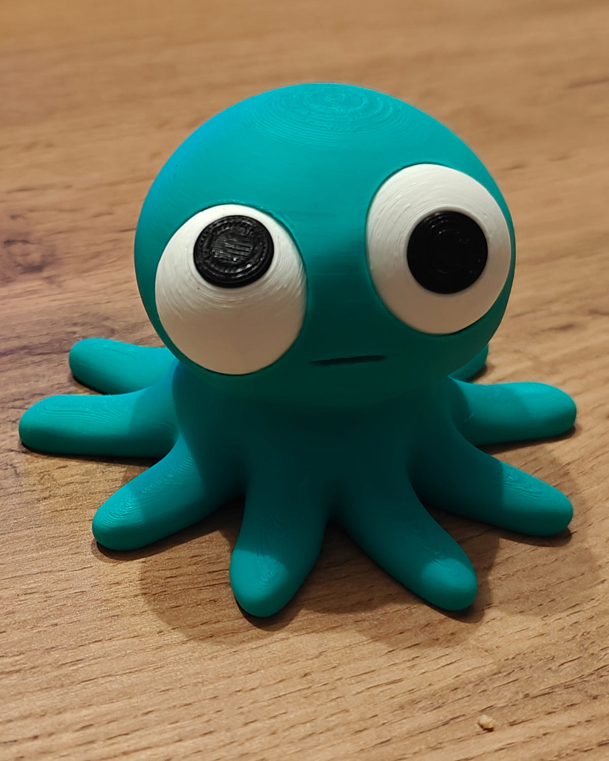 Figurine de pieuvre rigolote aux yeux mobiles, gros plan sur fond blanc