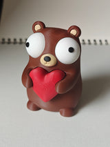 Gros plan d'une petite figurine d'ours avec cœur et grands yeux mobiles