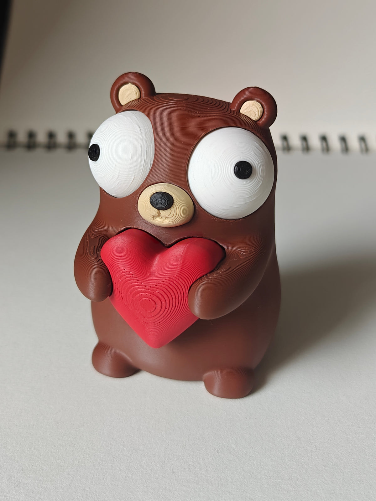 Gros plan d'une petite figurine d'ours avec cœur et grands yeux mobiles
