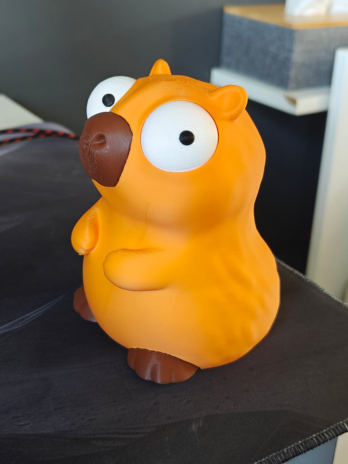 Figurine de capybara aux grands yeux mobiles, vue de face sur fond blanc