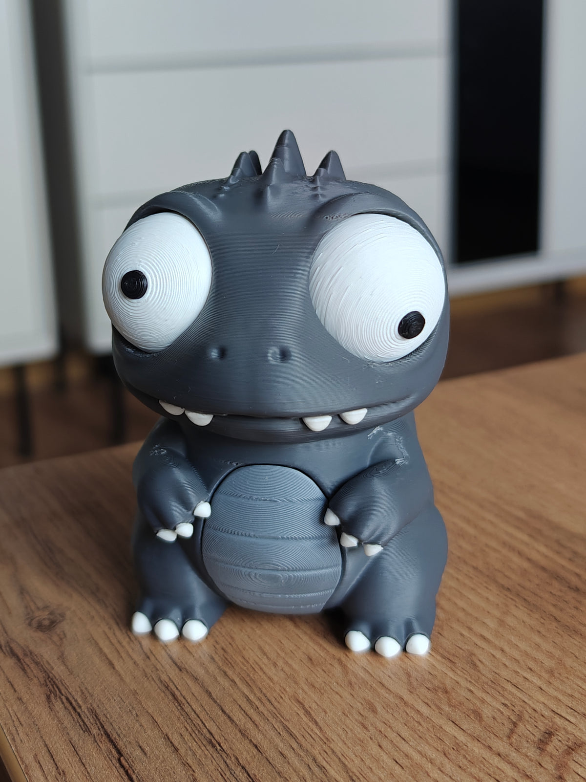 Figurine de dino-monstre kaiju aux grands yeux mobiles, vue de face