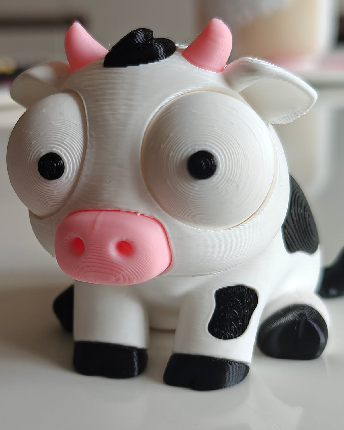 Gros plan d'une figurine de vache blanche et noire amusante aux grands yeux mobiles