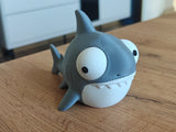 Figurine de requin rigolote aux grands yeux mobiles sur fond blanc