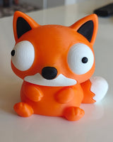Figurine de renard Foxie sur un bureau près d'une plante et d'un mug