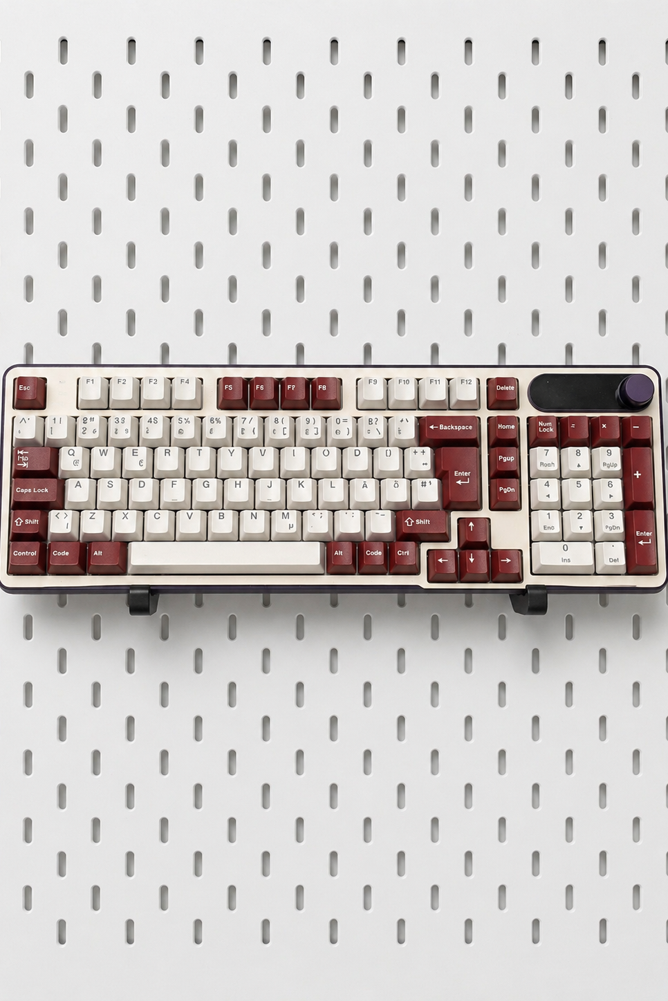 Deux supports de clavier noirs sur un panneau perforé IKEA Skådis blanc avec claviers mécaniques