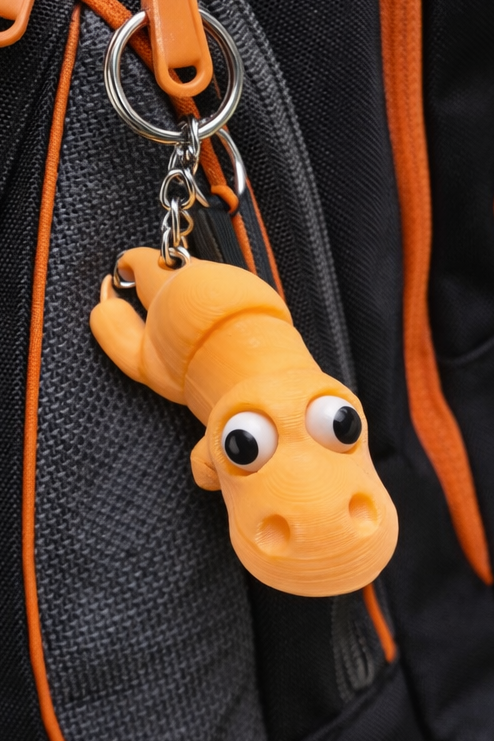 Porte-clés dinosaure orange imprimé en 3D avec yeux mobiles et anneau en métal