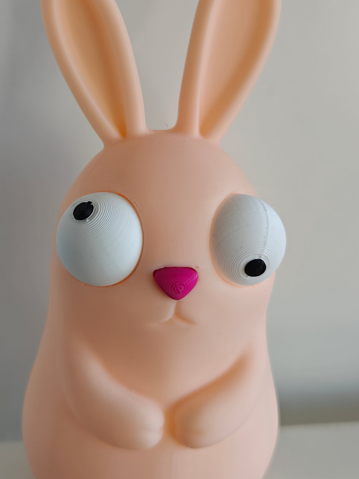 Figurine de lapin de Pâques rigolote aux grands yeux mobiles sur fond blanc