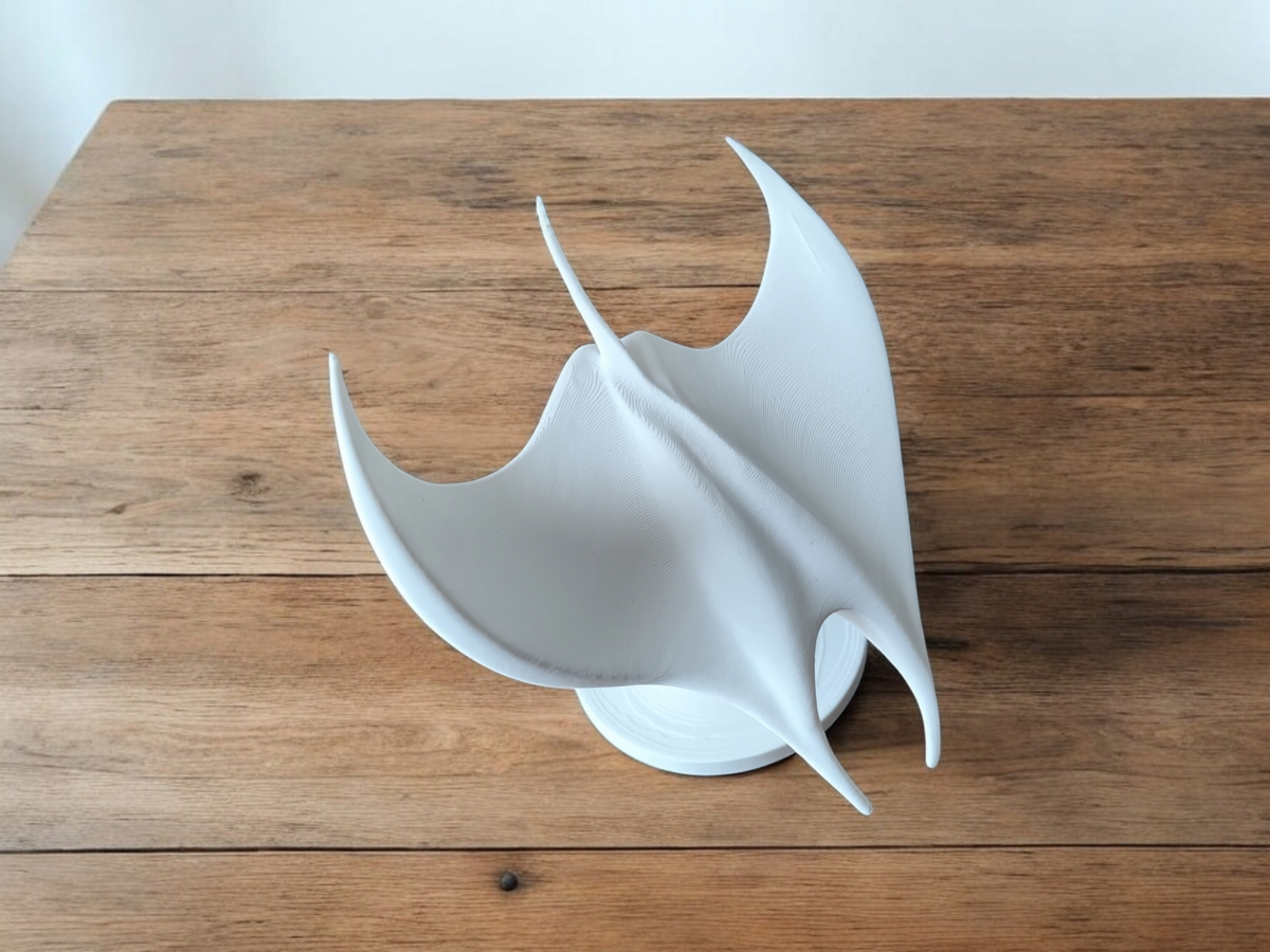 Gros plan de la surface blanche lisse et des ailes rabattues vers l'arrière de la sculpture de raie manta