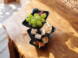 Plat de service à trois étages sur le plan de travail avec snacks et gâteaux