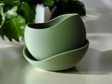 Détail de la texture ondulée d'un pot de fleurs minimaliste avec trou de drainage