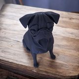 Gros plan d'une sculpture de carlin minimaliste à surface lisse noir mat