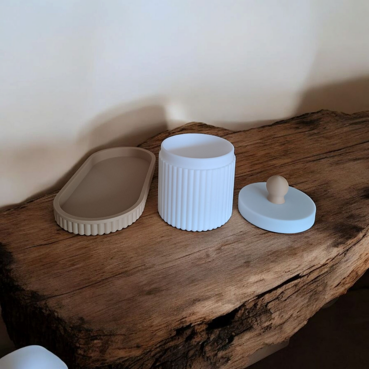Gros plan d'un pot à bijoux cannelé avec couvercle et plateau assorti, rose et blanc