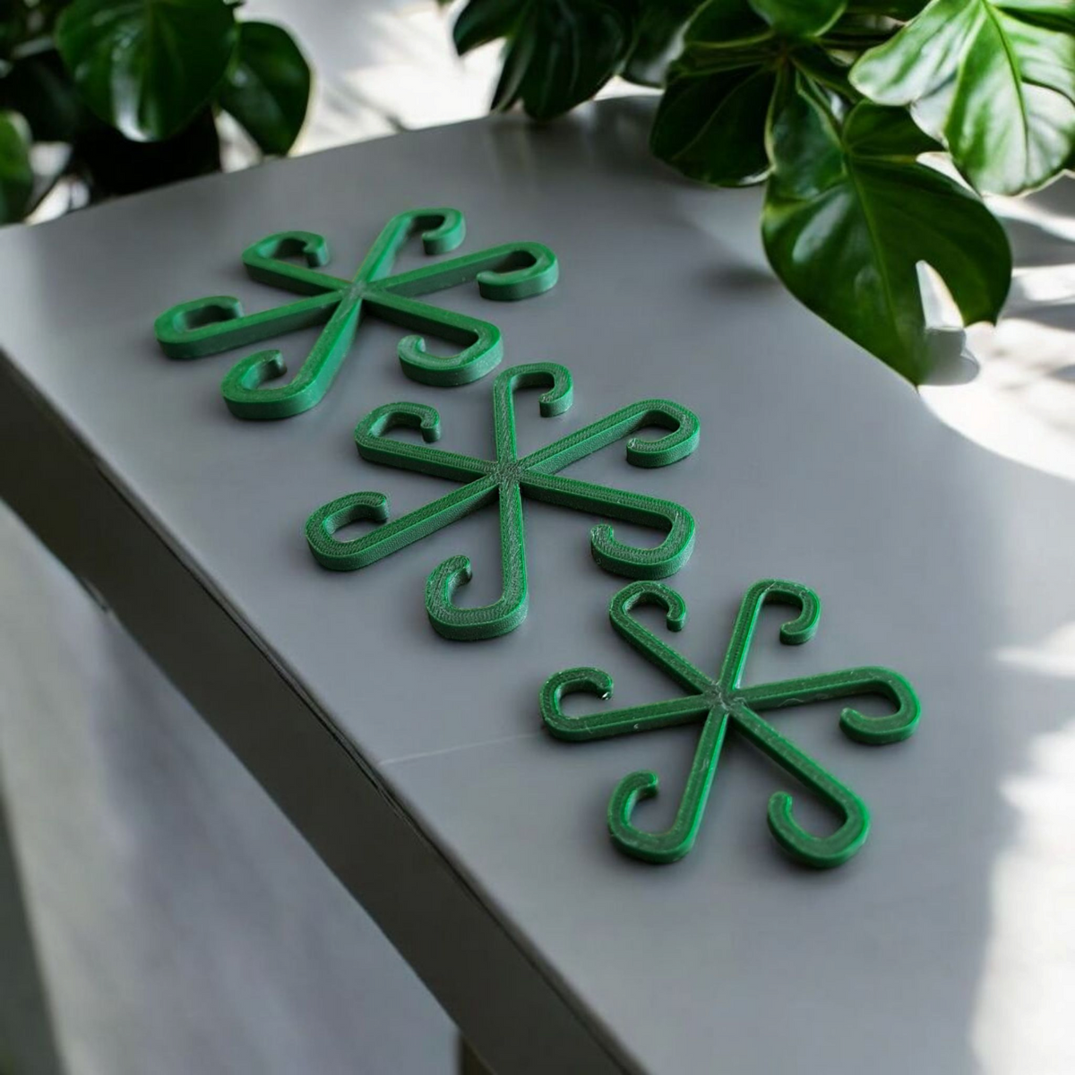 Trois crochets tuteurs dans des plantes en pot sur un rebord de fenêtre lumineux