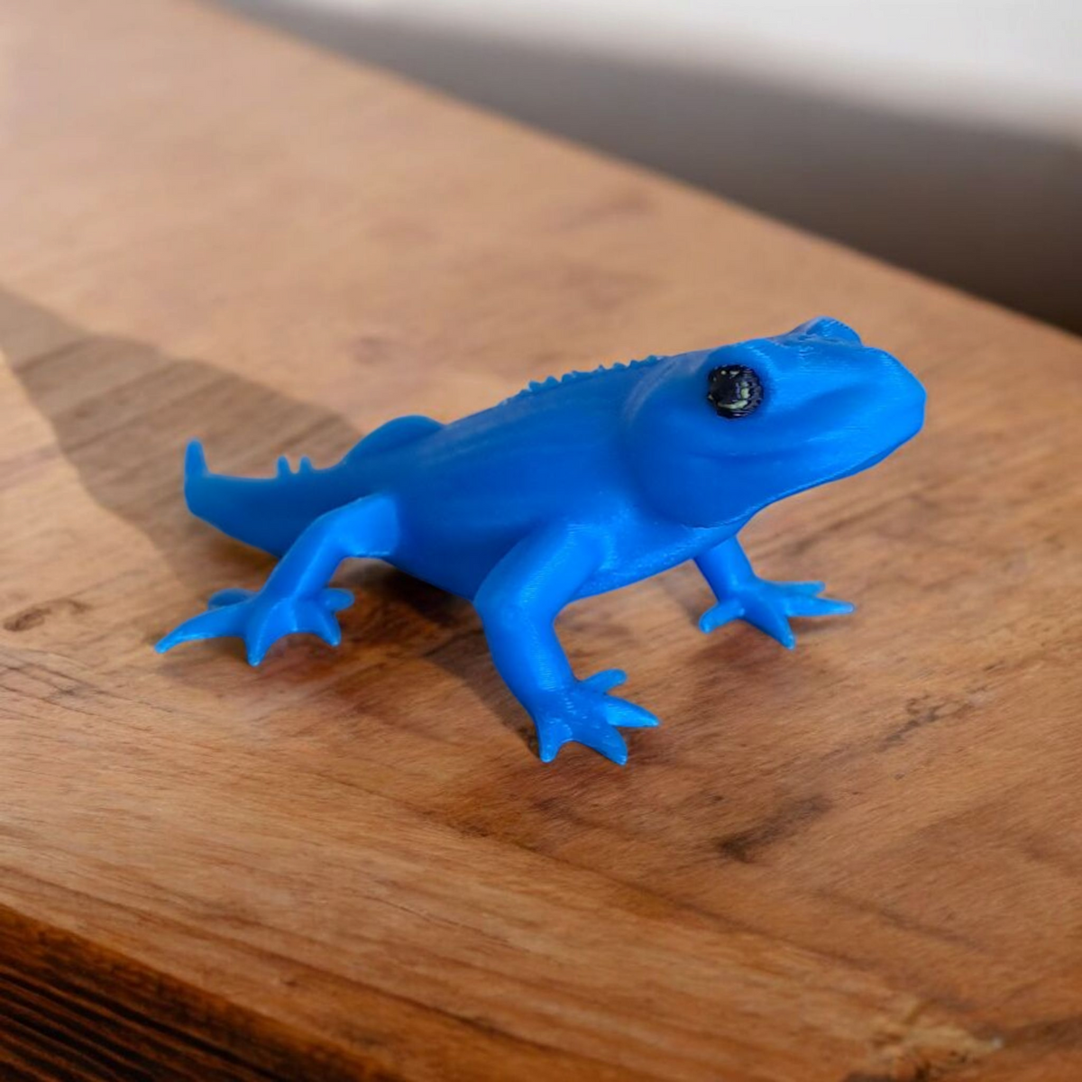 Petite figurine gecko sur une étagère avec décoration minimaliste