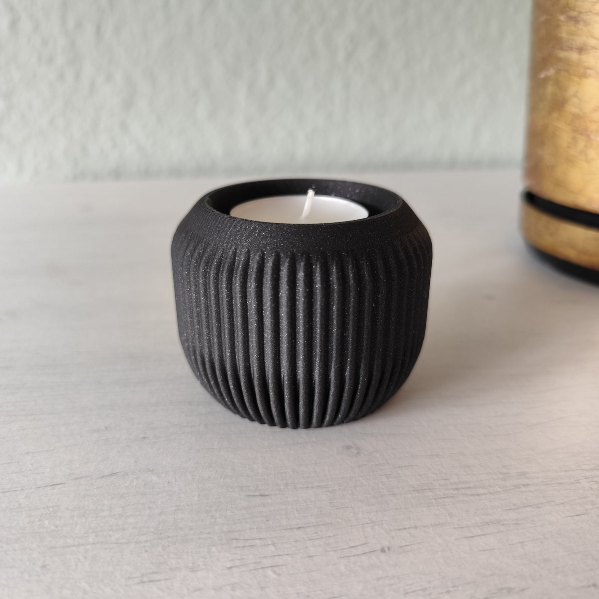 Photophore minimaliste avec bougie LED allumée sur une étagère en bois