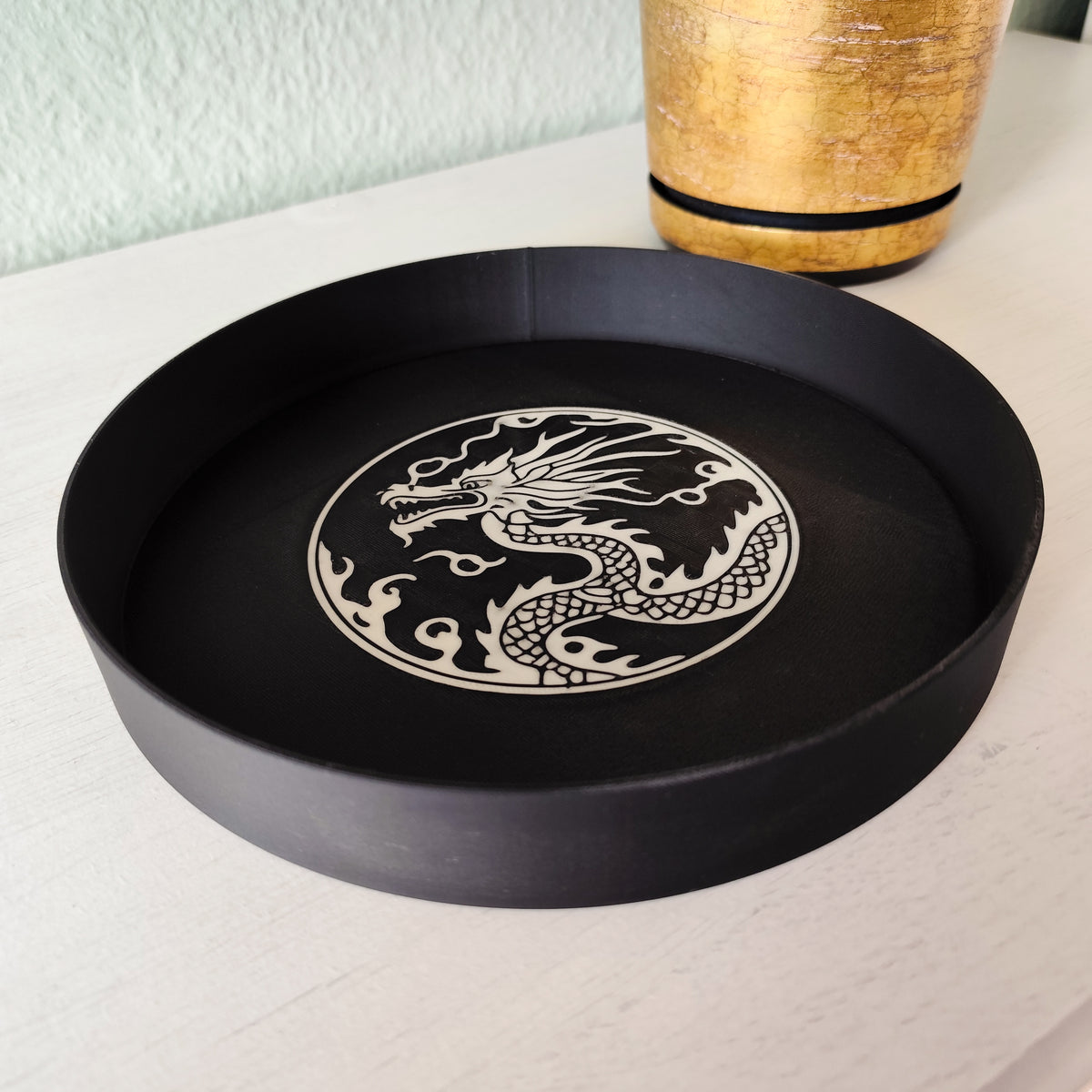 Plateau à relief de dragon sur un bureau avec clés et petits objets