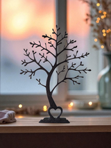 Présentoir minimaliste en forme d'arbre sur une étagère blanche avec une déco neutre