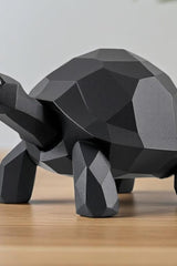 Gros plan d'une sculpture de tortue low poly à surface facettée et lignes épurées