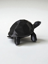 Gros plan d'une sculpture de tortue low poly à surface facettée et lignes épurées