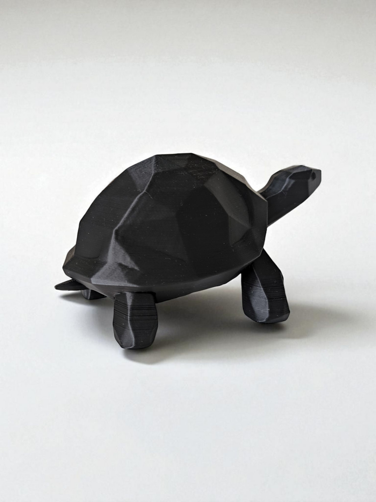 Gros plan d'une sculpture de tortue low poly à surface facettée et lignes épurées
