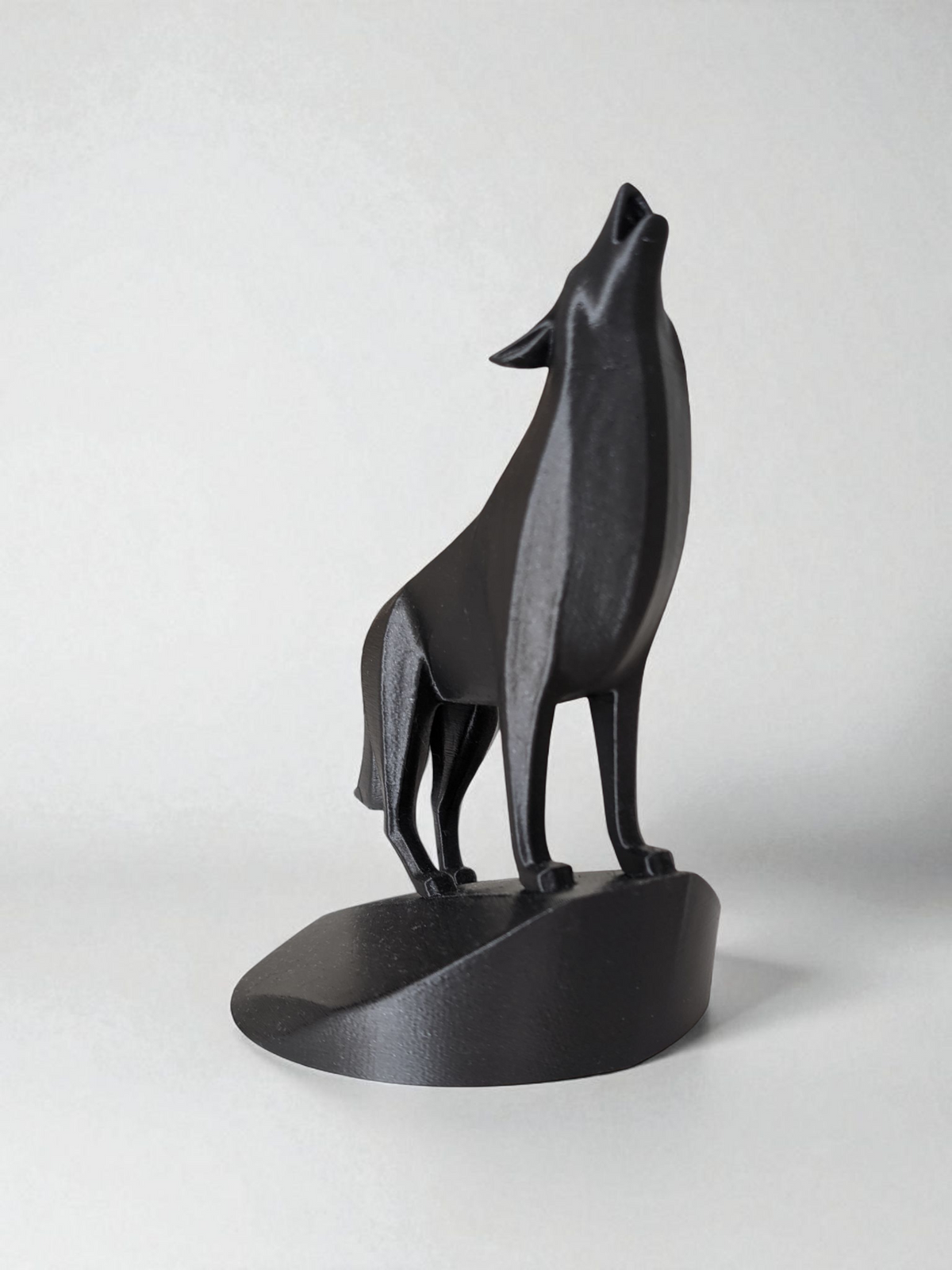 Gros plan d'une sculpture de loup minimaliste aux surfaces géométriques et à la gueule ouverte