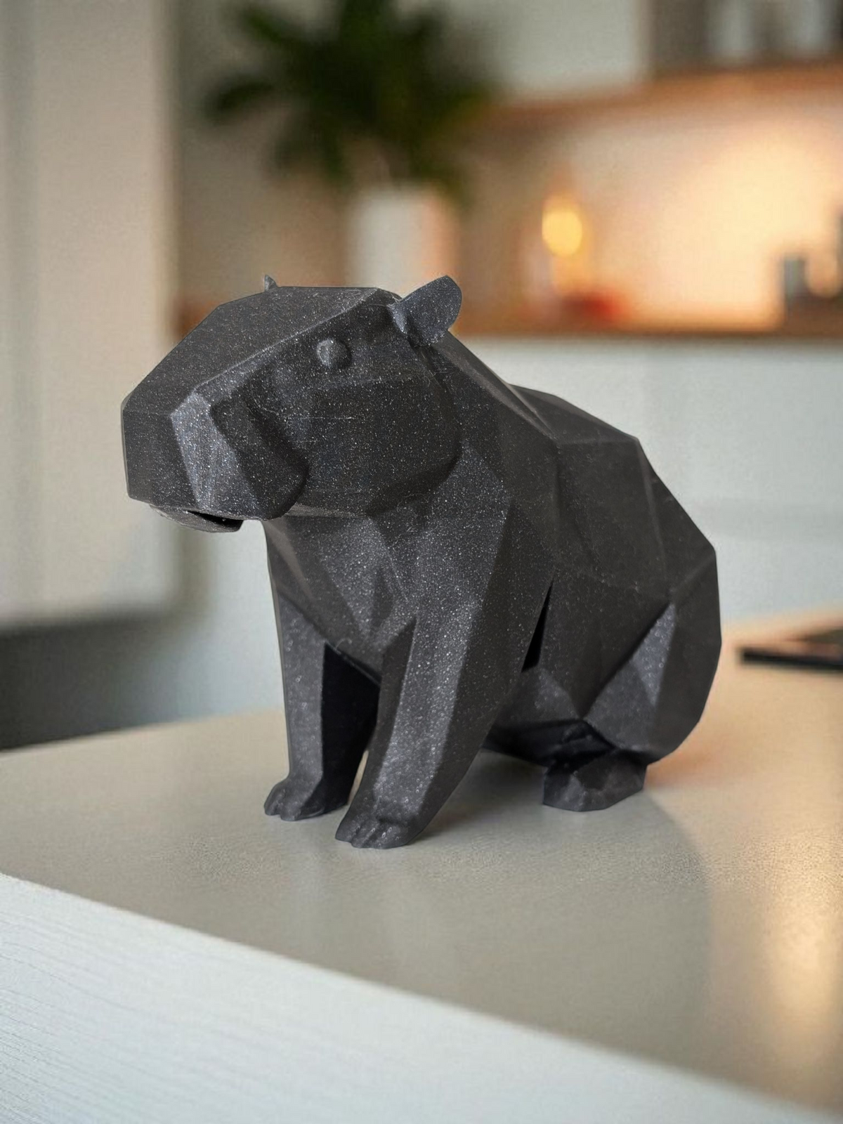 Sculpture de capybara low poly à la surface géométrique facettée, en posture paisible