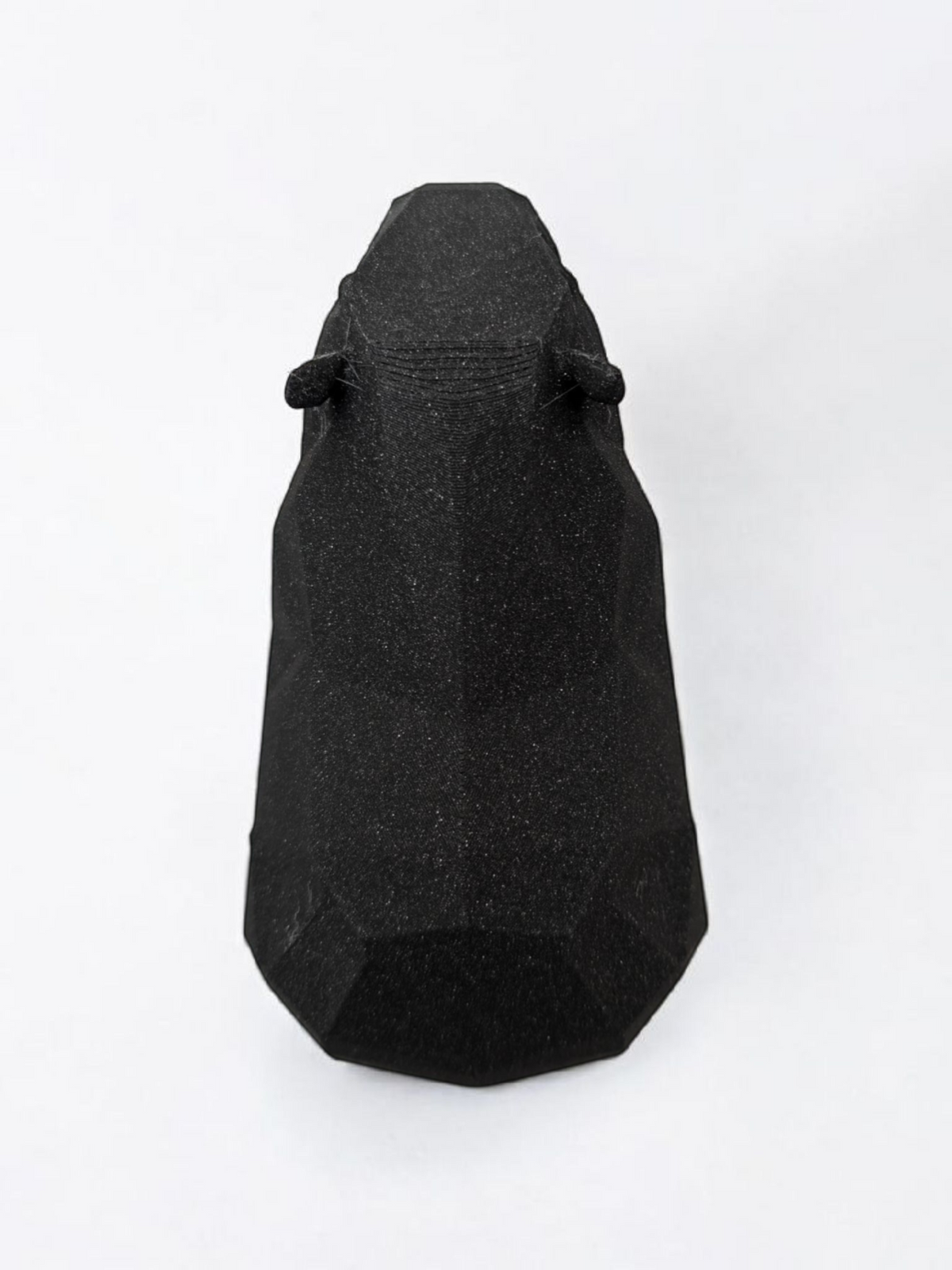 Sculpture de capybara low poly à la surface géométrique facettée, en posture paisible