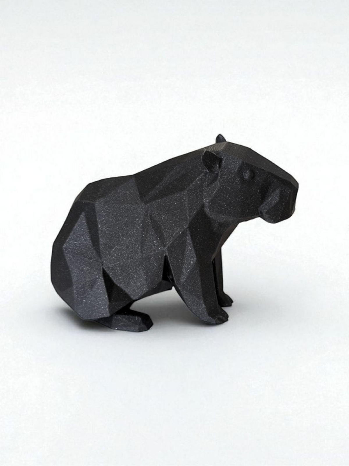 Sculpture de capybara low poly à la surface géométrique facettée, en posture paisible