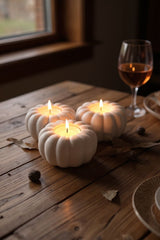 Photophore citrouille pour l'automne avec bougies allumées sur une étagère en bois