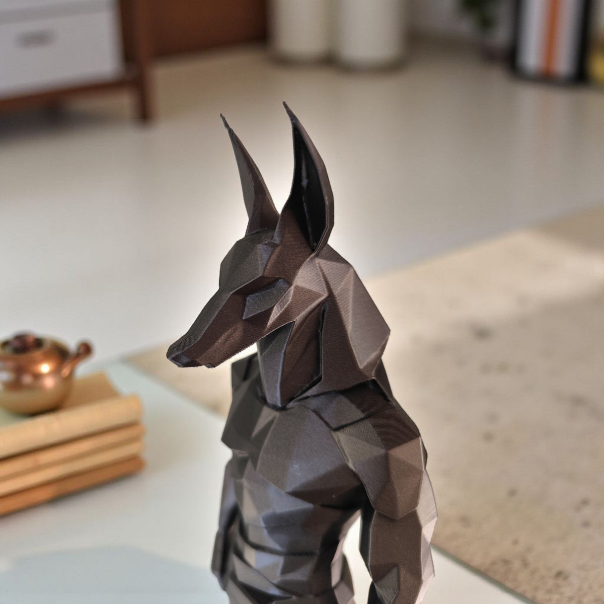 Statue d'Anubis low poly sur une étagère claire avec une déco minimaliste