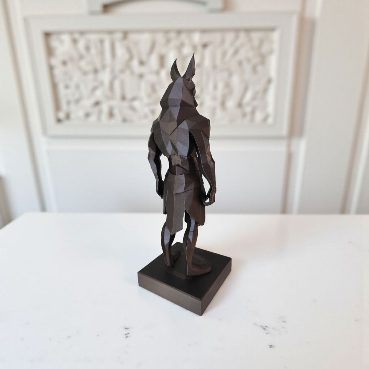 Gros plan d'une statue d'Anubis low poly aux facettes géométriques et au design anguleux