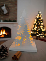 Scène de Noël illuminée avec photophore LED brillant doucement sur une étagère blanche