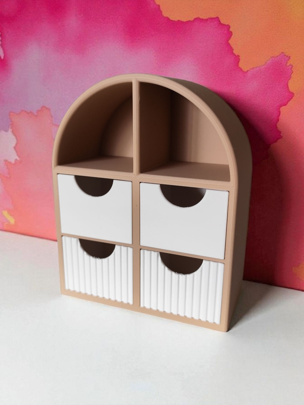 Petite étagère à bijoux avec tiroirs striés sur une commode de chambre près de livres