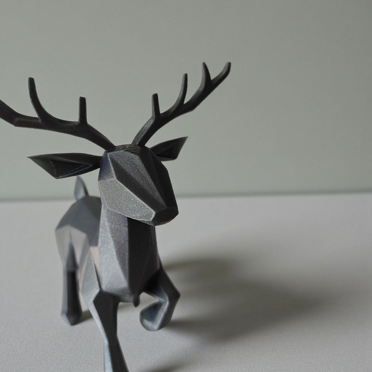 Gros plan d'un renne low poly minimaliste à surface facettée, avec ses bois
