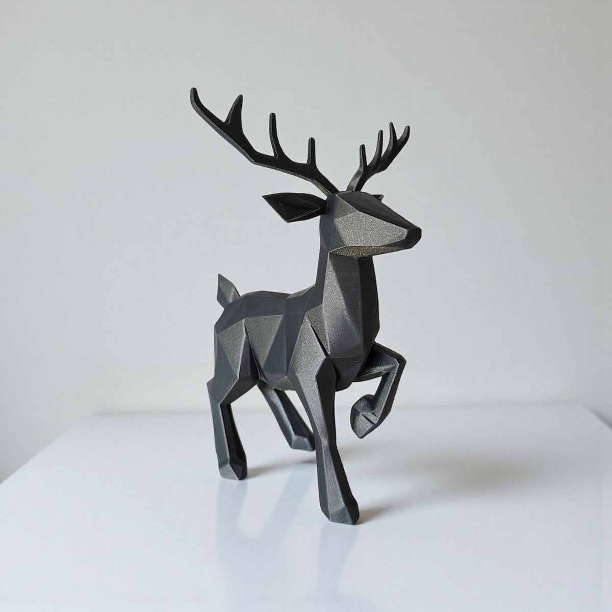 Gros plan d'un renne low poly minimaliste à surface facettée, avec ses bois
