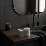 Distributeur de disques de coton sur une étagère de salle de bain avec plante et céramique
