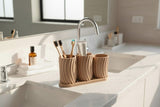 Set de porte-brosses à dents Little Family sur un meuble de salle de bain avec savon et serviettes