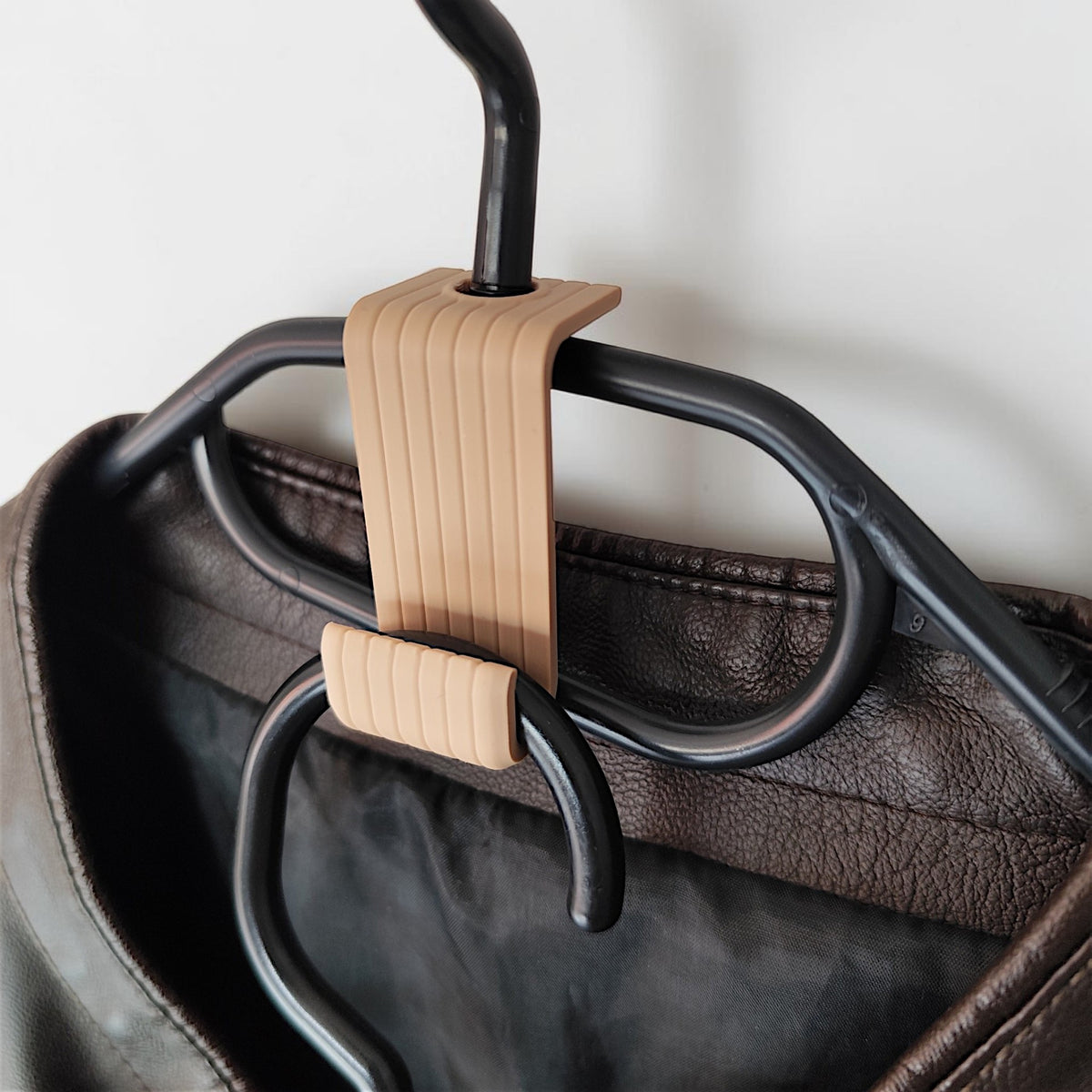 Crochet de cintre astucieux reliant deux cintres en bois